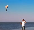 Happy young man with flying a kite on the beach Royalty Free Stock Photo