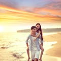 Happy young Man Giving Woman Piggyback On Summer Beach Royalty Free Stock Photo