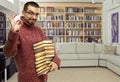 Happy young man in glasses with the books at library Royalty Free Stock Photo