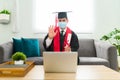 Happy young man graduating in a virtual graduation at home Royalty Free Stock Photo