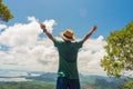 Happy young man with hands stretched up stands high in mountains - Concept of success, healthy lifestyle, harmony with nature Royalty Free Stock Photo