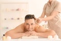 Happy young man having massage in spa salon Royalty Free Stock Photo