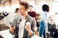 Happy young man holding cellphone and coffee cup Royalty Free Stock Photo