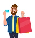 Happy young man holding shopping bags. Male character showing a credit, debit, ATM, bank card in hand. Modern lifestyle, digital. Royalty Free Stock Photo