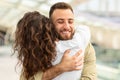 Happy Young Man Hugging His Wife At Airport After Flight Arrival