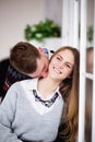 Happy young man kissing his girlfriend in the neck Royalty Free Stock Photo