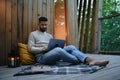 Happy young man with laptop resting outdoors in a tree house, weekend away and remote office concept. Royalty Free Stock Photo