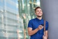 Happy young man leaning against wall outside with cell phone Royalty Free Stock Photo