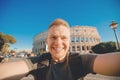 Happy young man making selfie in front of Colosseum in Rome, Italy. Concept travel trip Royalty Free Stock Photo