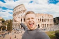 Happy young man making selfie and smile Colosseum in Rome, Italy. Concept travel Royalty Free Stock Photo
