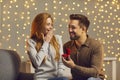 Happy young man making wonderful surprise for his girlfriend, giving her beautiful ring Royalty Free Stock Photo