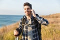 Happy young man outside in free alternative vacation camping talking by mobile phone Royalty Free Stock Photo