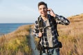 Happy young man outside in free alternative vacation camping talking by mobile phone Royalty Free Stock Photo