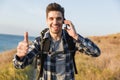 Happy young man outside in free alternative vacation camping talking by mobile phone Royalty Free Stock Photo