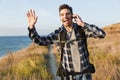 Happy young man outside in free alternative vacation camping talking by mobile phone Royalty Free Stock Photo