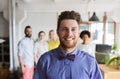 Happy young man over creative team in office Royalty Free Stock Photo