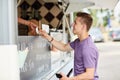 Happy young man paying money at food truck Royalty Free Stock Photo