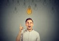 Happy young man pointing at light bulb has a solution Royalty Free Stock Photo