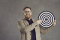 Happy young man pointing at shooting target as metaphor for setting business goal Royalty Free Stock Photo