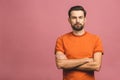 Happy young man. Portrait of handsome young man in casual keeping arms crossed and smiling while standing against pink background Royalty Free Stock Photo