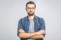 Happy young man. Portrait of handsome young man in casual shirt keeping arms crossed and smiling while standing against grey Royalty Free Stock Photo