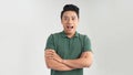 Happy young man. Portrait of handsome young man keeping arms crossed and smiling while standing against grey background Royalty Free Stock Photo