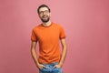 Happy young man. Portrait of handsome young man in casual smiling while standing against pink background Royalty Free Stock Photo
