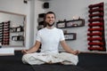 Happy young man with positive smile with a beard practicing yoga in the fitnes studio. Healthy lifestyle