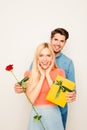 Happy young man presenting rose and yellow gift to his excited girlfriend Royalty Free Stock Photo