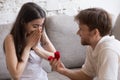 Happy young man propose to his girlfriend sitting on sofa Royalty Free Stock Photo