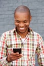 Happy young man reading text message on mobile phone Royalty Free Stock Photo