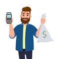 Happy young man is showing or holding money bag, cash bag and POS terminal or credit, debit card swiping payment machine in hand. Royalty Free Stock Photo