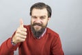 Happy young man showing OK sign with his thumb up and blinking Royalty Free Stock Photo