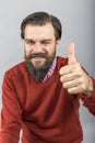 Happy young man showing OK sign with his thumb up and blinking