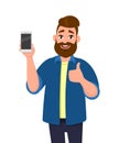 Happy young man showing smartphone and showing thumbs up or like sign.