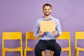 Happy young man sitting alone and holding up thought bubble Royalty Free Stock Photo