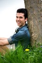 Happy young man sitting in nature Royalty Free Stock Photo