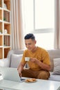 Happy young Man sitting in sofa and using laptop Royalty Free Stock Photo