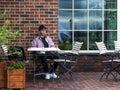 Happy young man sitting at a table near a wall Royalty Free Stock Photo