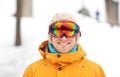 Happy young man in ski goggles outdoors