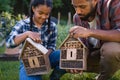 Happy young man with small sister holding bug hotels outdoors in backyard. Royalty Free Stock Photo