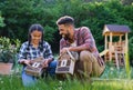 Happy young man with small sister holding bug hotels outdoors in backyard, laughing. Royalty Free Stock Photo