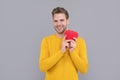 Happy young man smile holding Valentines heart grey background, love