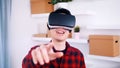 Happy young man smiling while experiencing virtual reality and pointing finger towards camera Royalty Free Stock Photo