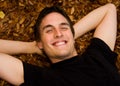 Happy young man smiling in fall leaves