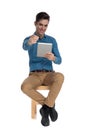 Happy young man smiling, holding tab and pointing finger Royalty Free Stock Photo