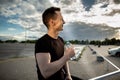 Happy young man smiling during morning workout and drinking water from a bottle. Break during sports, healthy lifestyle Royalty Free Stock Photo