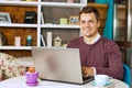 Happy young man smiling and works on his laptop Royalty Free Stock Photo