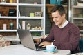 Happy young man smiling and works on his laptop Royalty Free Stock Photo