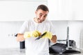 Happy young man standing and washing dishes on the kitchen Royalty Free Stock Photo